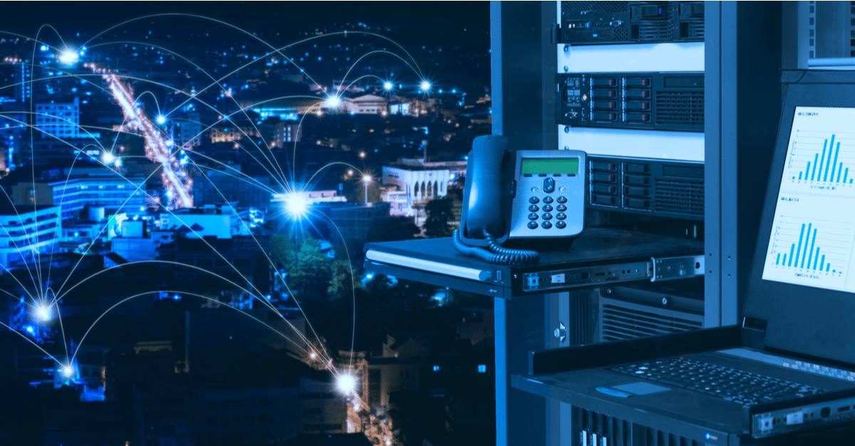 VoIP phone and server equipment with a cityscape background and network connection lines.